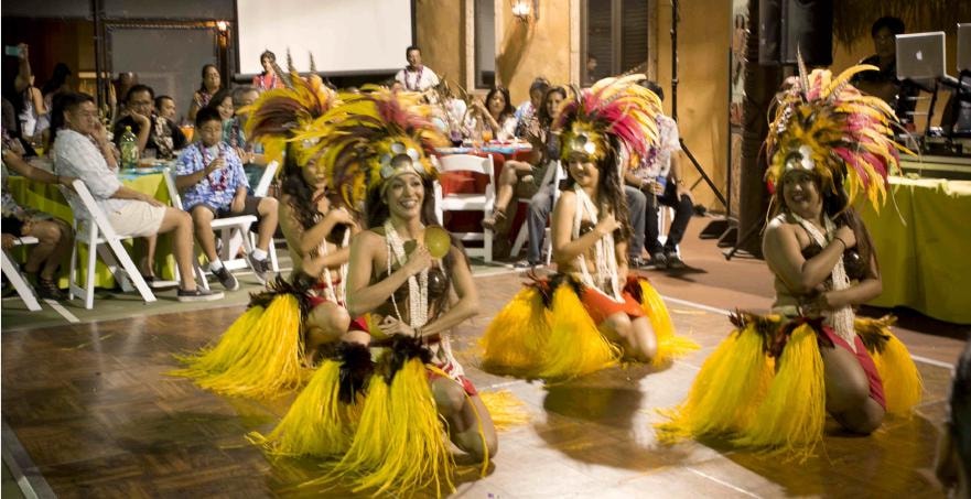 Manea Events performers in yellow feathered costumes at a San Diego luau